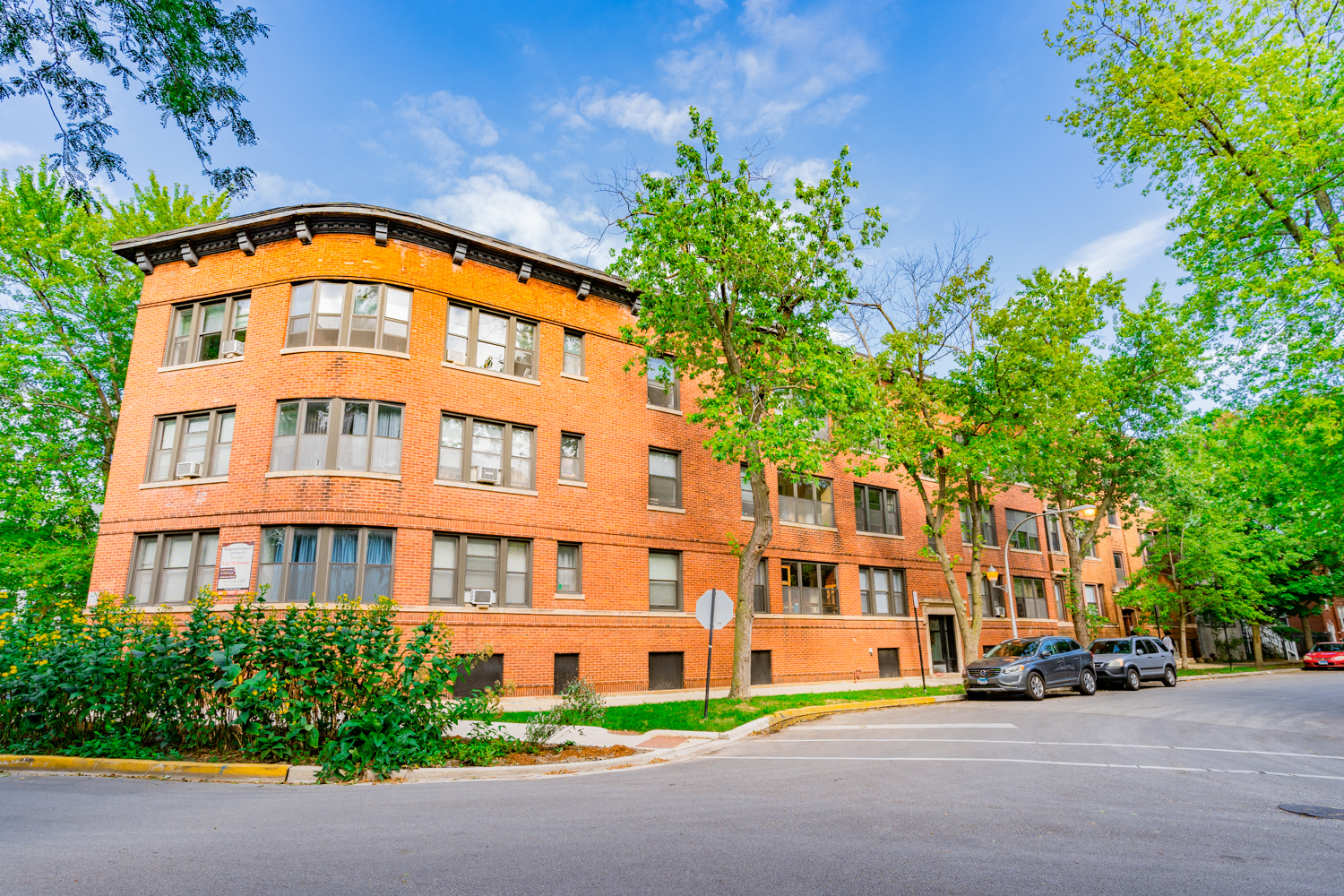 a large brick building with cars parked in front of it